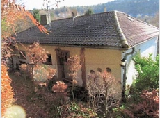 Einfamilienhaus mit unbebauten Grundstücken und Garage